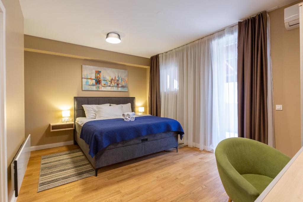 a bedroom with a blue bed and a green chair at Hotel Sky in Zadar
