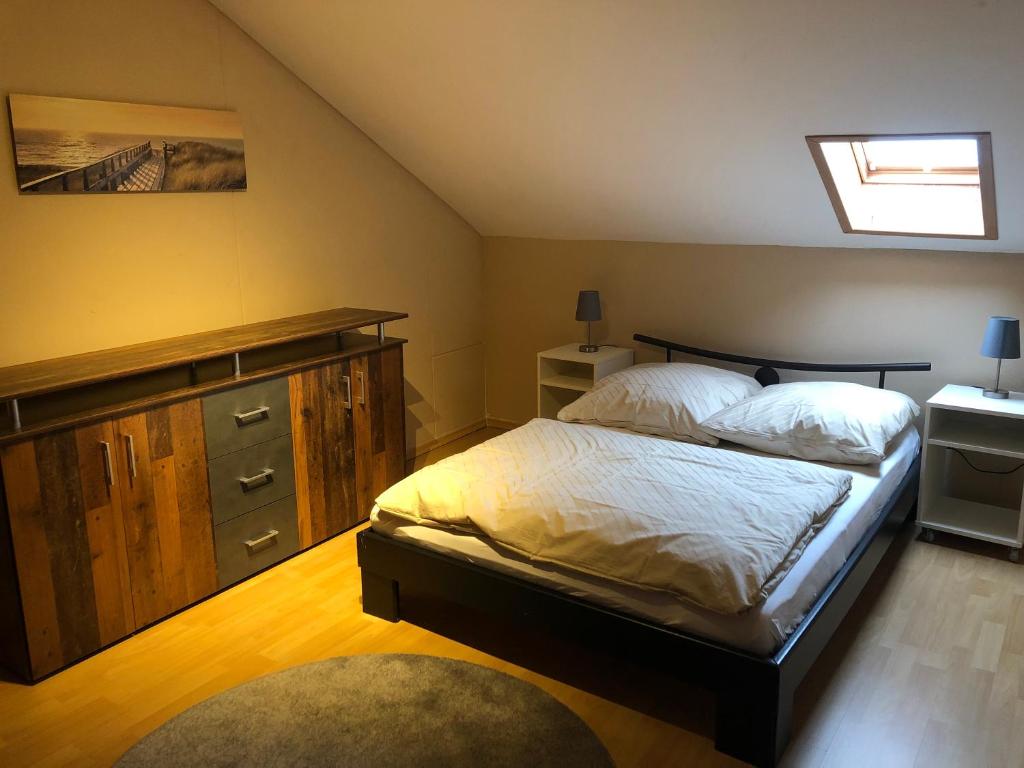 een slaapkamer met een bed, een dressoir en een raam bij Ferienwohnung Schanz in Konken