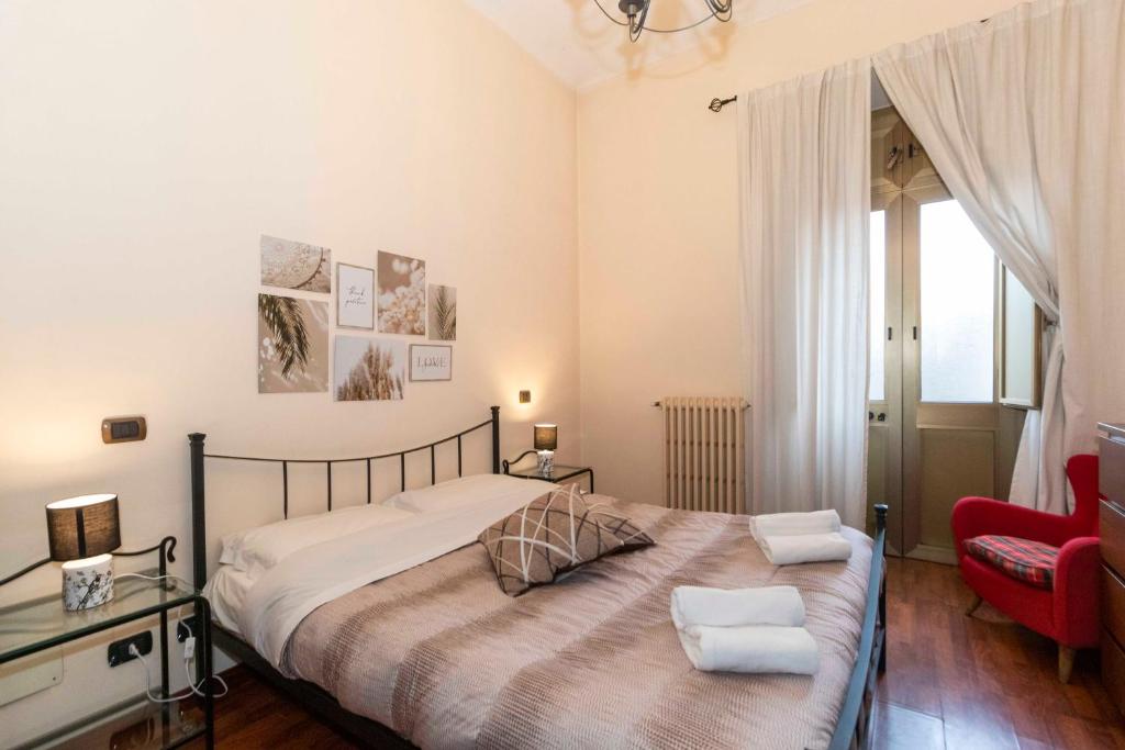 una camera da letto con un letto e una sedia rossa di Piazza Statuto Comfy APT - with 2 Balconies a Torino