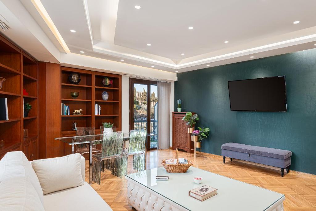 uma sala de estar com um sofá branco e uma televisão em Acropolis Prestige Residence em Atenas
