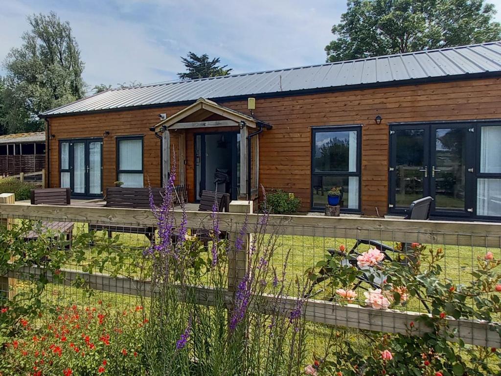 a wooden house with a garden in front of it at Lords View in Ruckinge