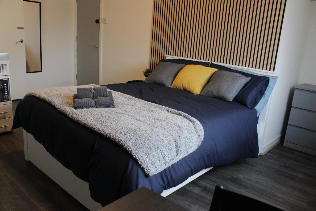 una camera da letto con un grande letto con piumone blu di Superb Studio Flats in City Centre a Southampton