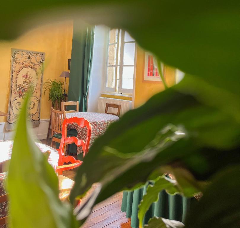 a living room with a green plant in the foreground at Maison Sainte Barbe in Autun