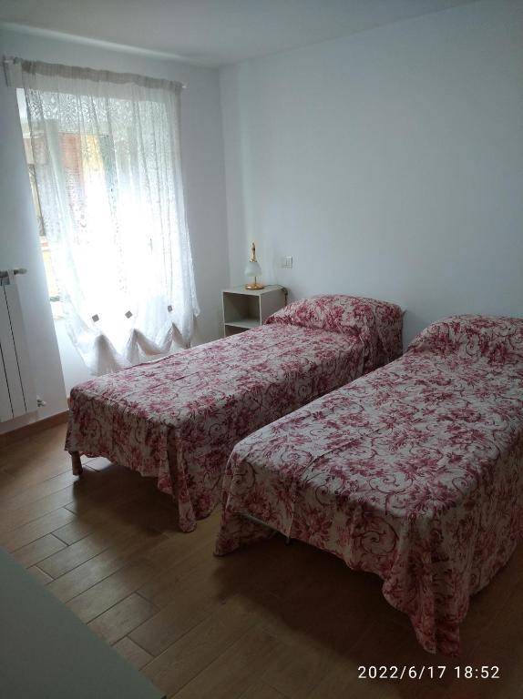 1 dormitorio con 2 camas y ventana en Appartamento arredato Segni Roma CASA ANNA MARIA, en Segni