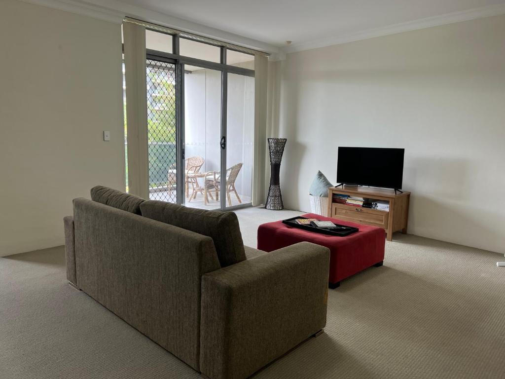 uma sala de estar com um sofá, uma mesa e uma televisão em Westmead Home away from home em Westmead