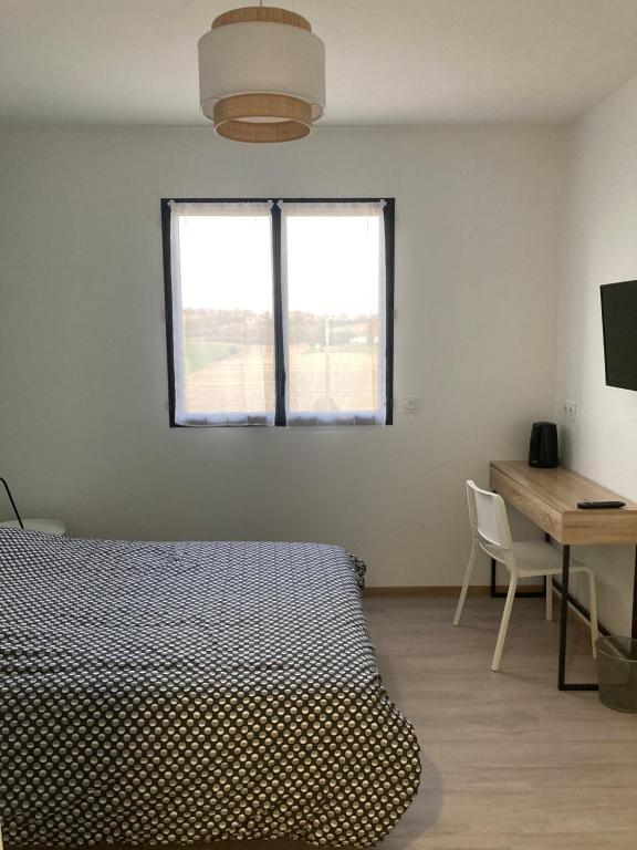 1 dormitorio con cama, escritorio y ventana en Ferme Hôtel Boulage en Marquefave