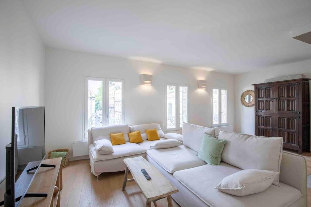 a living room with a white couch and yellow pillows at Bel Appart avec CLIM en DUPLEX - TERRASSE - Wifi in Avignon
