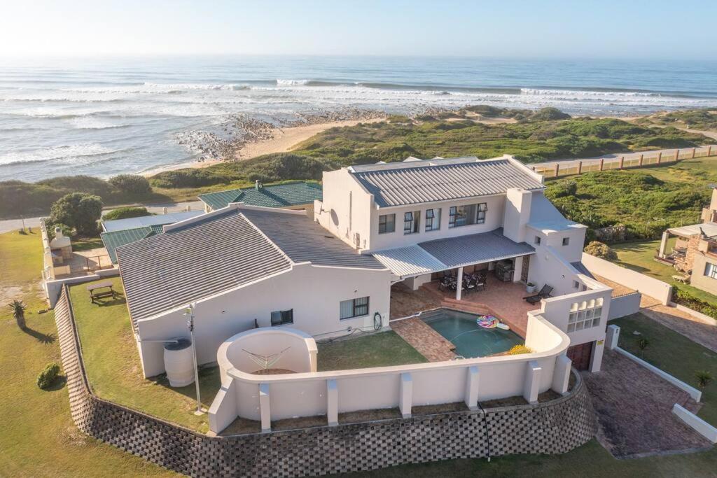 una vista aérea de una casa blanca con el océano en Double-Story Holiday Home with Pool & Seaview, en Port Alfred