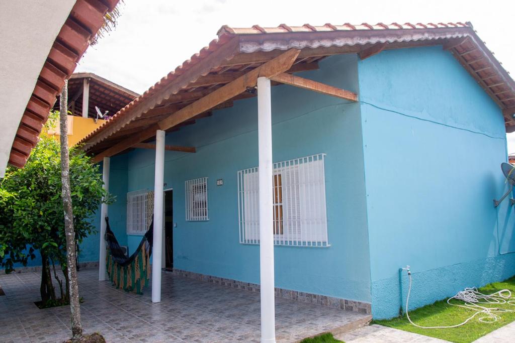 une maison bleue avec un toit en gambrel dans l'établissement Linda casa a 950m do mar em Bertioga SP, à Bertioga