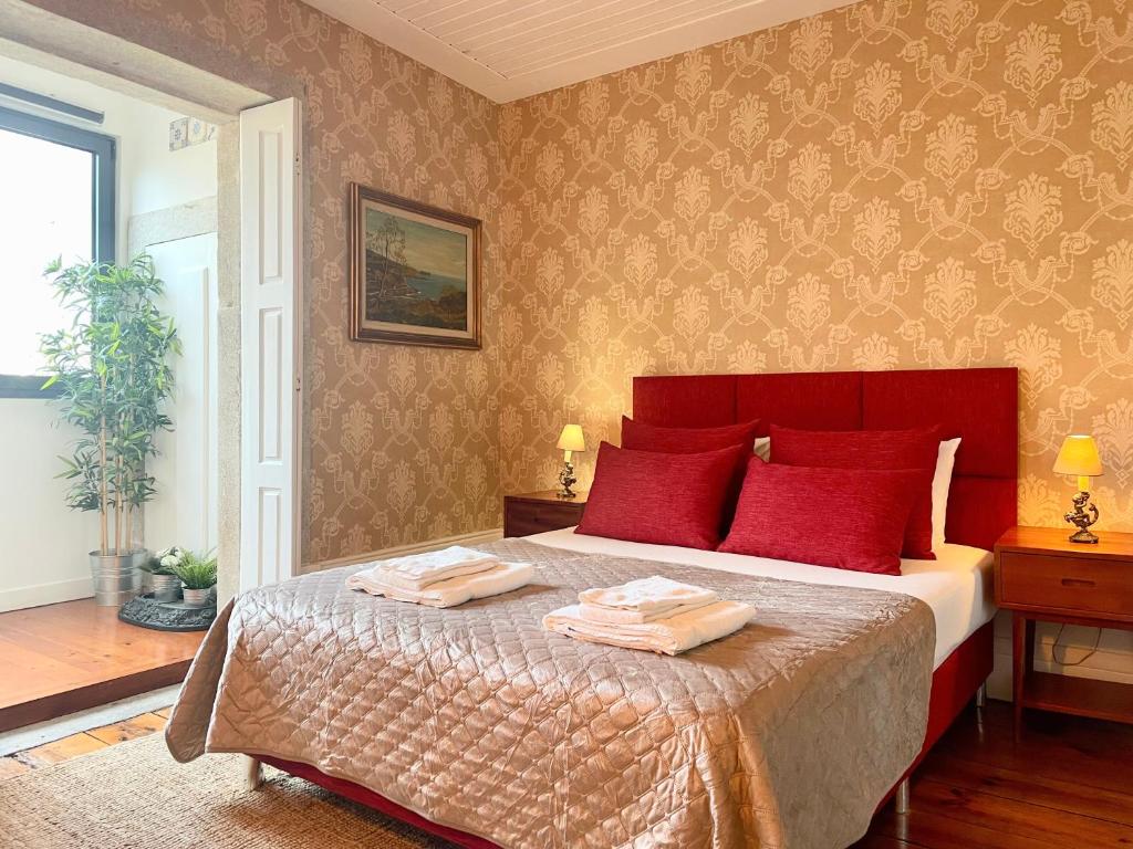 sypialnia z dużym łóżkiem z czerwonymi poduszkami w obiekcie The Brewmaster's House w Porto