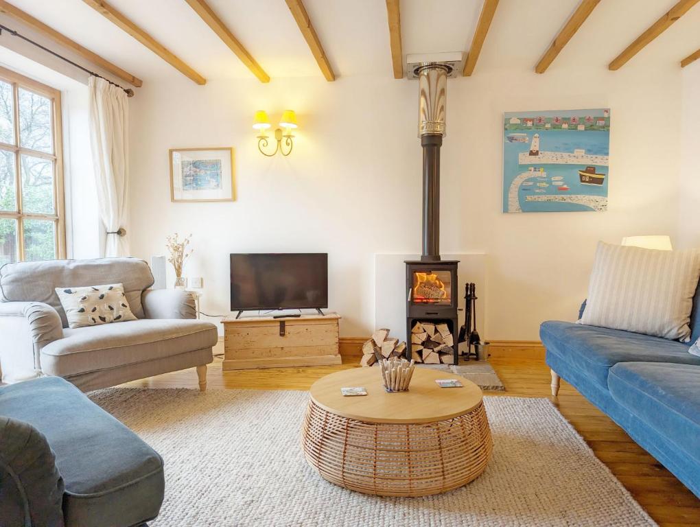 a living room with a couch and a fire place at Stable Cottage in Woodmancote