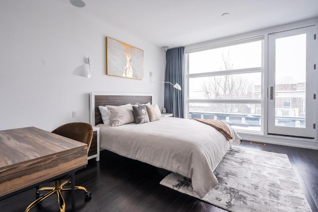 トロントにあるGLOBALSTAY Exclusive 4 Bedroom Townhouse in Downtown Toronto with Parkingのベッドルーム1室(ベッド1台、デスク、窓付)