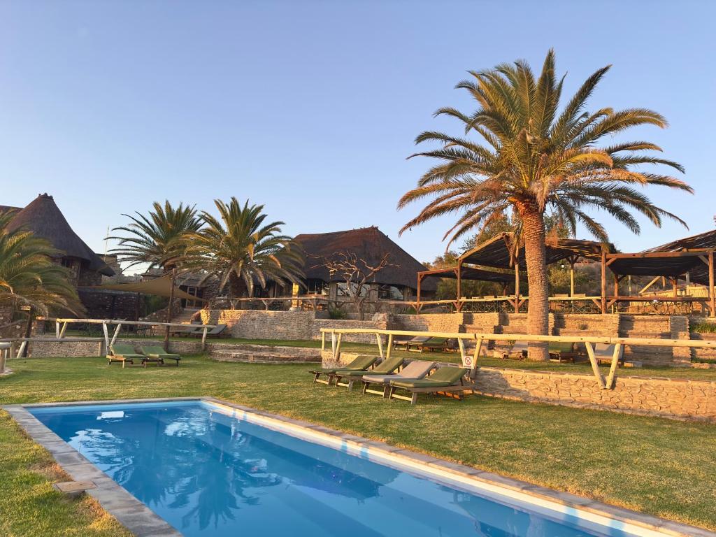una piscina frente a un complejo con palmeras en Onjala, en Eorondemba