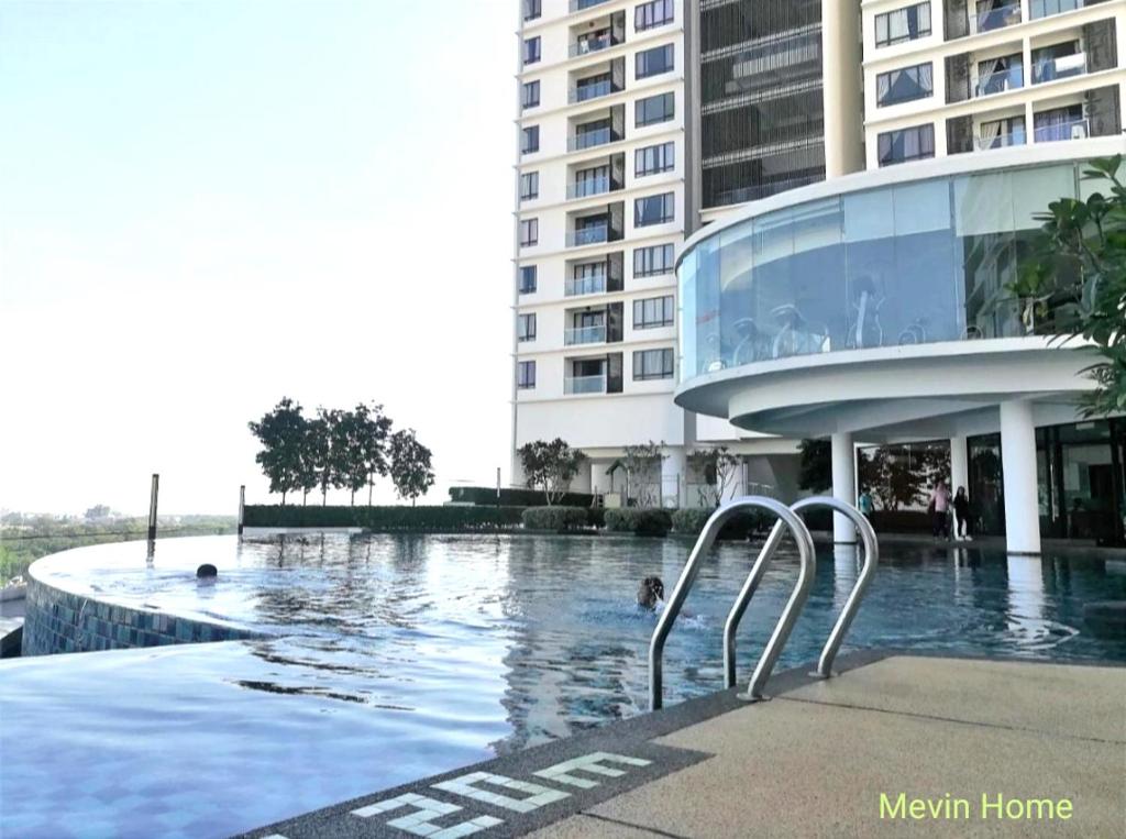 a swimming pool in front of a large building at Mevin Woodsbury Suite Butterworth Penang in Butterworth