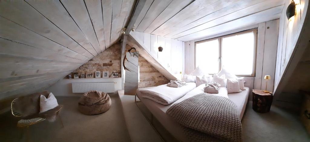 a attic room with two beds and a window at BACHMEIERs Stüber'l in Altdorf bei Nuernberg