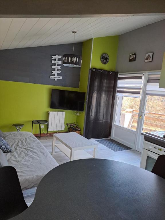 Vieille-BrioudeにあるAppartement terrasse +parkingのベッド、テーブル、キッチンが備わる客室です。