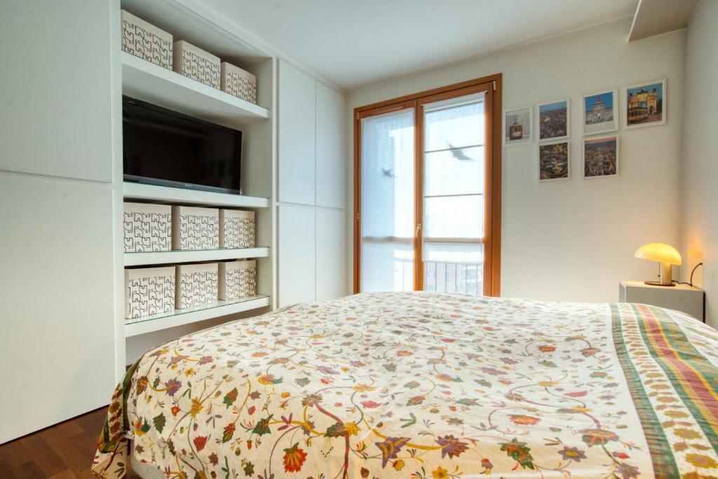 A bed or beds in a room at CaseOspitali - Casa Di Bibi, colorato ed elegante bilocale vicino al Naviglio Martesana per 4