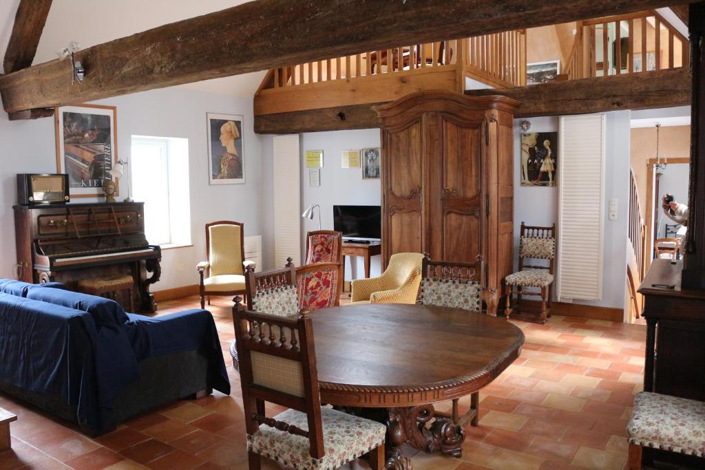 sala de estar con mesa de madera y sillas en Chez Célestine, en Souvigny