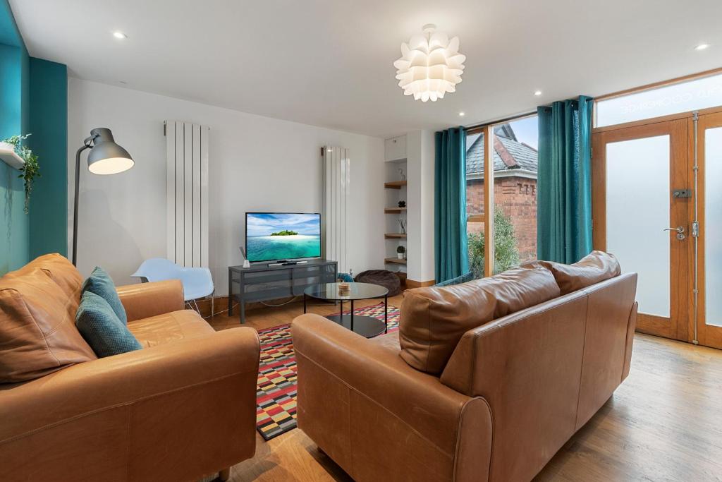 Sala de estar con 2 sofás y TV en The Old Cooperage by Staytor Accommodation, en Exeter