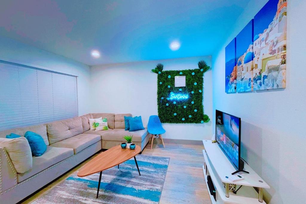 uma sala de estar com um sofá e uma televisão de ecrã plano em Modern Santorini Suite Houston NRG TMC Luxurious Walkable em Houston