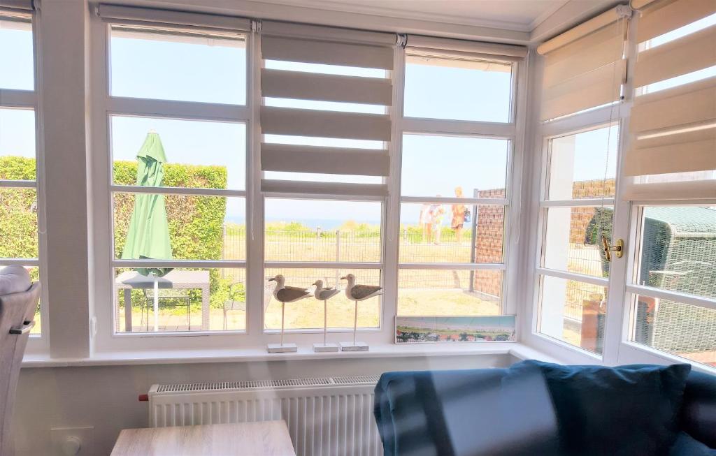 a living room with windows with ducks on the wall at Strandbungalow Jette in Glowe