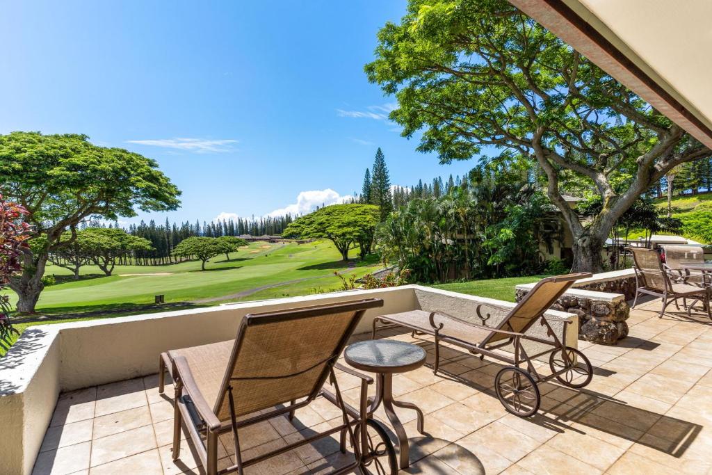 eine Terrasse mit Stühlen, einem Tisch und einem Golfplatz in der Unterkunft Sun, Beach, Golf Romantic Getaway! A Safe Place in Kahana