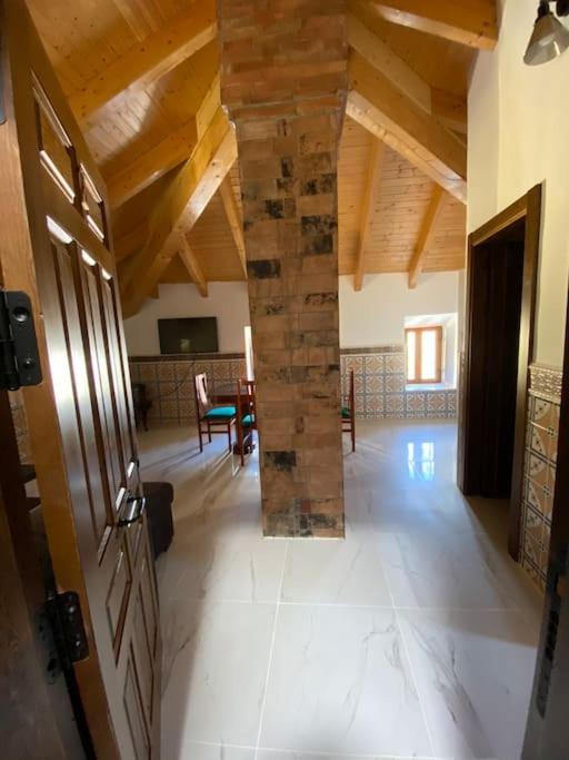 a living room with a stone pillar in a house at La carchata ático in Siete Aguas