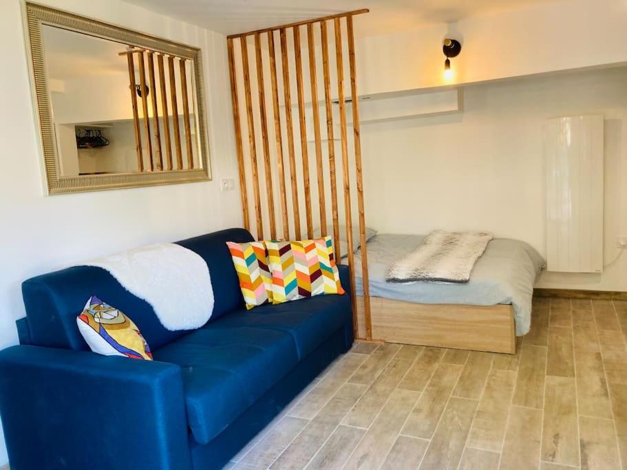 un soggiorno con divano blu e letto di Appart'Hotel au Pradet a Le Pradet