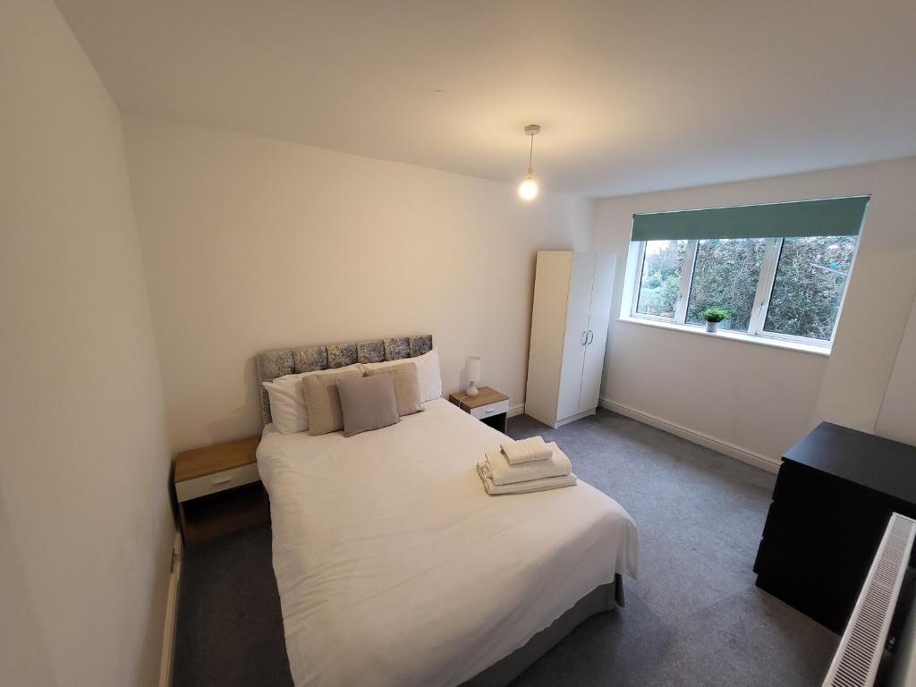 a bedroom with a large white bed with a window at Modern 3 bed Walking Distance to Wimbledon Tennis! in London