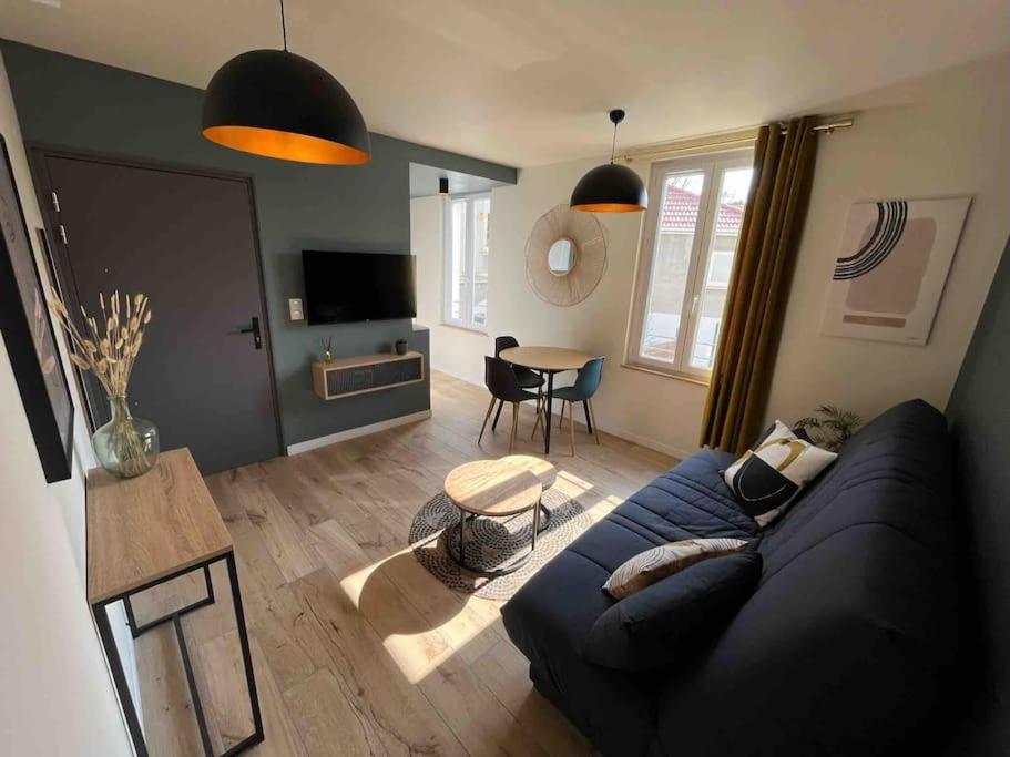 een woonkamer met een blauwe bank en een tafel bij Appartement Proche Hôpital La Tronche in La Tronche