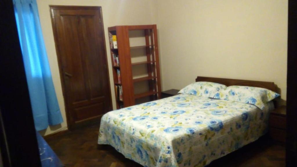 1 dormitorio con cama y estante para libros en Departamento gde a 1/2 cuadra plaza Indep. cochera en San Miguel de Tucumán