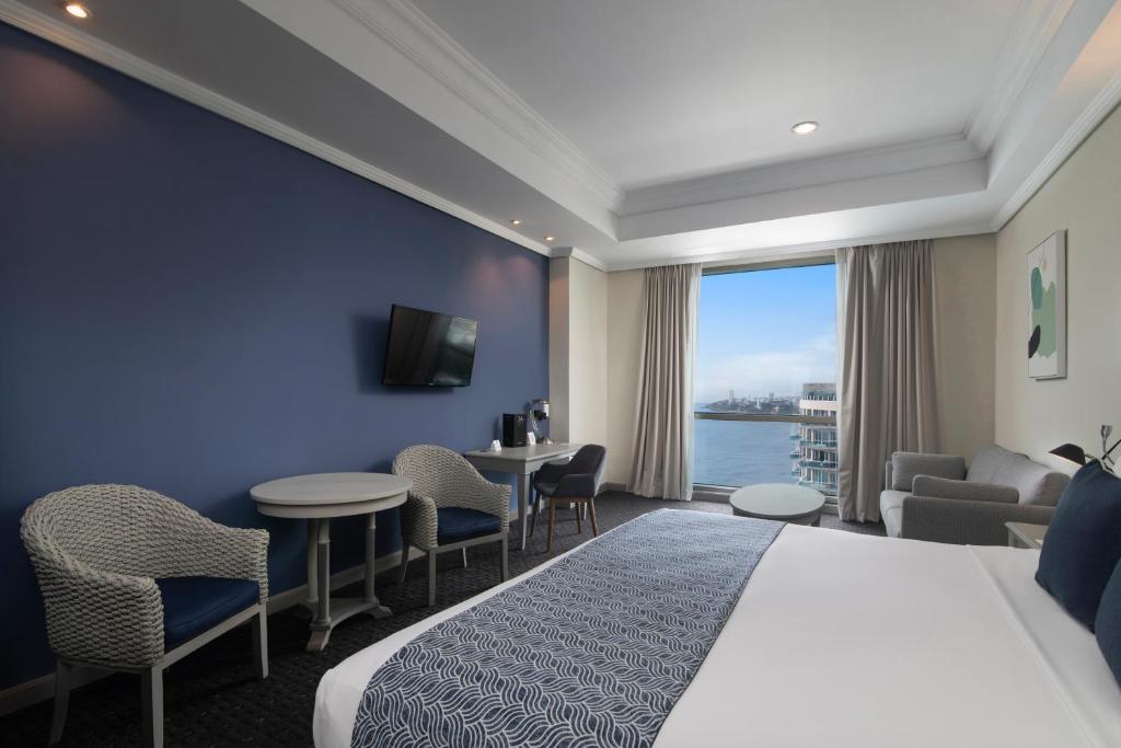 a hotel room with a bed and a view of the water at Catalonia Santo Domingo in Santo Domingo