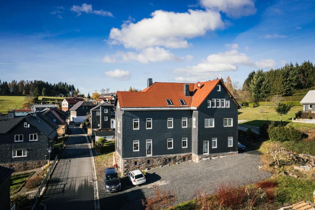 una vista aerea di una grande casa con tetto arancione di Ferienwohnungen Fertsch a Sonneberg