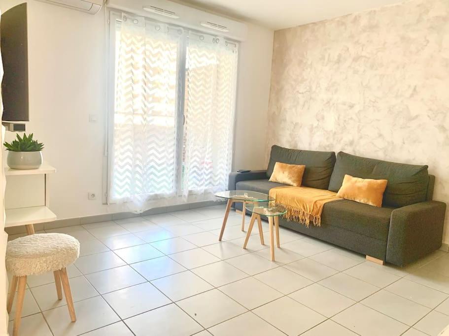 uma sala de estar com um sofá verde e uma mesa em Marseille 60 m2 terrasse et parking em Marselha