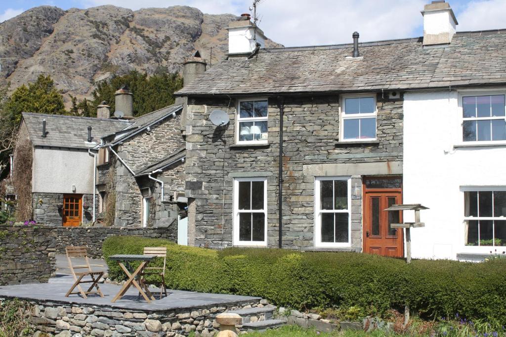 a stone house with a picnic table in front of it at 1 Kirkbeck Cottage Coniston in Coniston