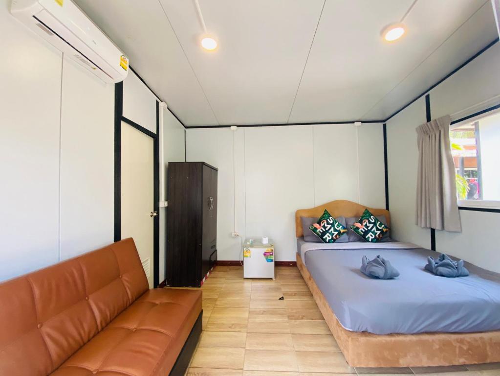 ナイヤンビーチにあるKORA-GREAT Airport Phuketのベッドルーム1室(ベッド2台、ソファ付)