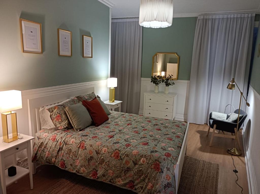 ein Schlafzimmer mit einem Bett, einem Stuhl und einem Spiegel in der Unterkunft Santo Cristo Apartments in Ponta Delgada