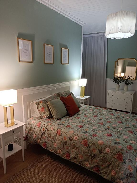 a bedroom with a bed and two tables and a mirror at Santo Cristo Apartments in Ponta Delgada