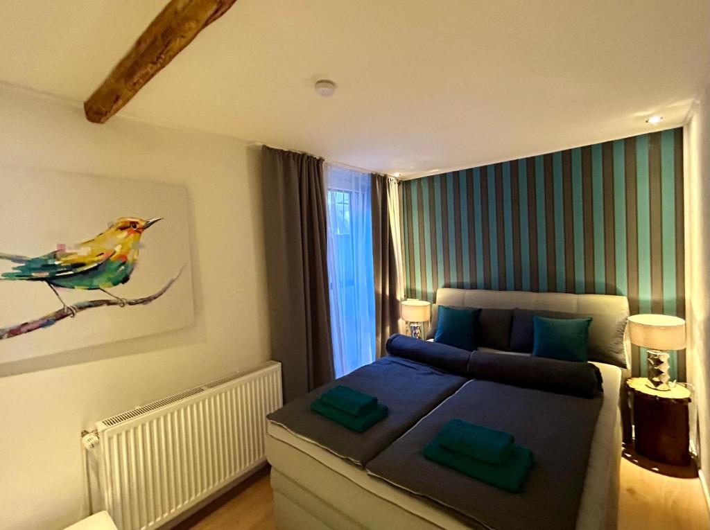 1 dormitorio con 1 cama y una pintura de un pájaro en Die Altstadt Appartements Caprice, en Goslar