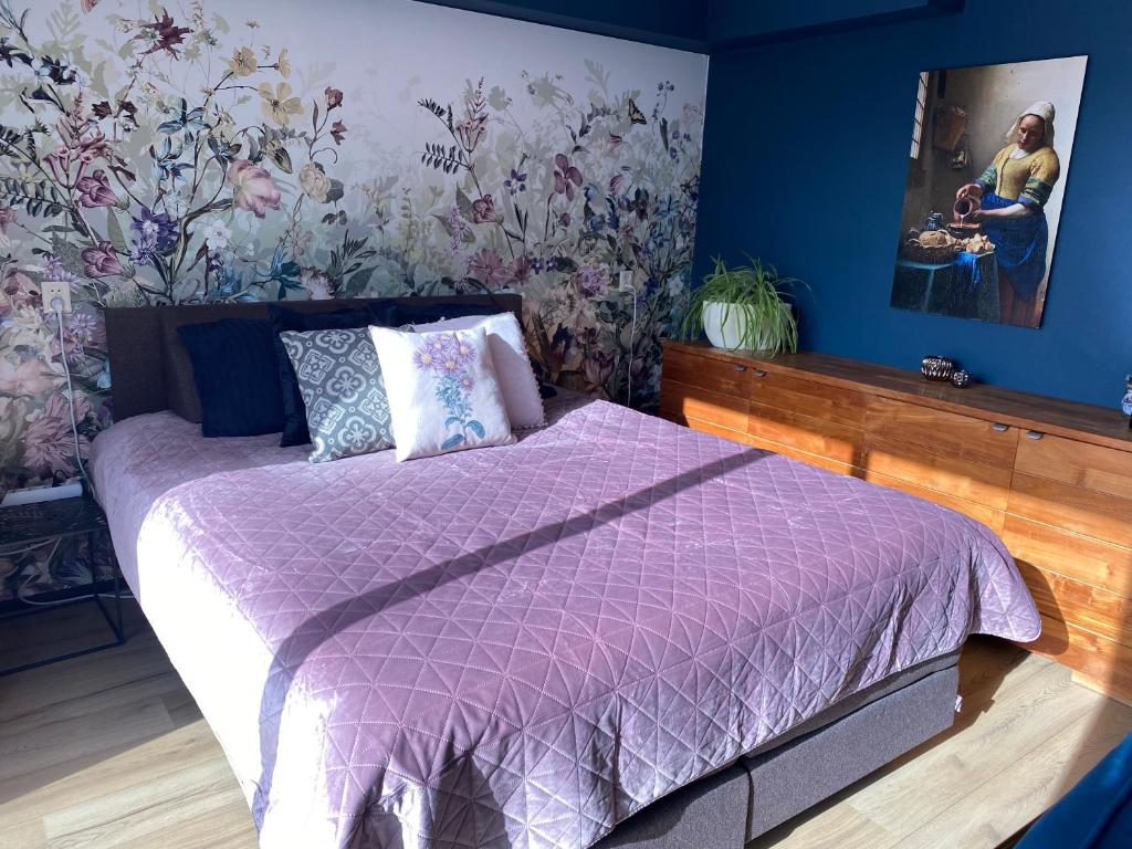 een slaapkamer met een bed met een paars dekbed bij BzB Jantina in Heerenveen