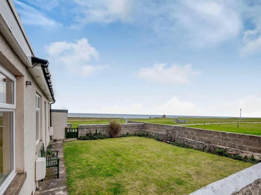 a view from the balcony of a house with a yard at Sea View Cottage in Inverallochy