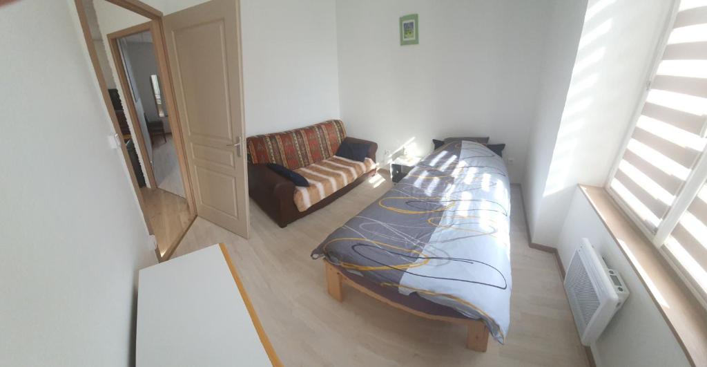 a small bedroom with a bed and a chair at Cramiland - Super appart 5 pers centre ville in Montbéliard