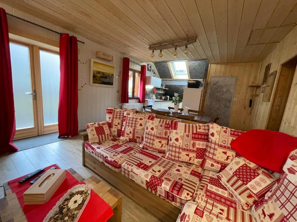 een woonkamer met een bank en rode gordijnen bij Magnifique T3 entre lac et montagne près d'Annecy in Montmin
