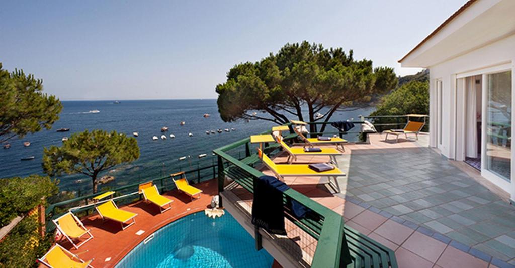 een huis met een zwembad met uitzicht op de oceaan bij Villa Felicita in Massa Lubrense