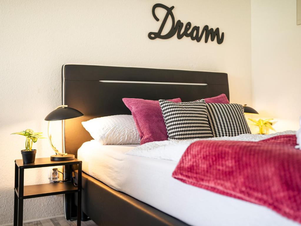 a bedroom with a bed with pink and white pillows at TRUTH - Winternest - Smart TV - Terrasse - Kamin in Brilon