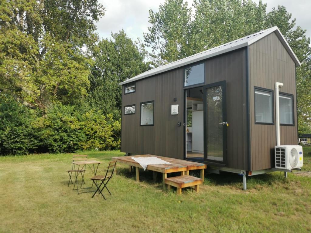 a tiny house with a picnic table and chairs at Sweet Hart 1 in Tamahere