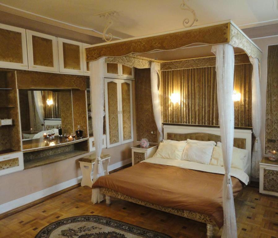 a bedroom with a canopy bed and a bathroom at Classic Apartment on Kievyan in Yerevan