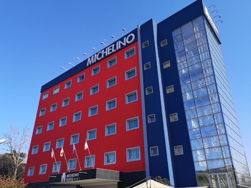波隆那的住宿－博洛尼亞米切里諾菲恩拉酒店，一座红色的建筑,上面有标志