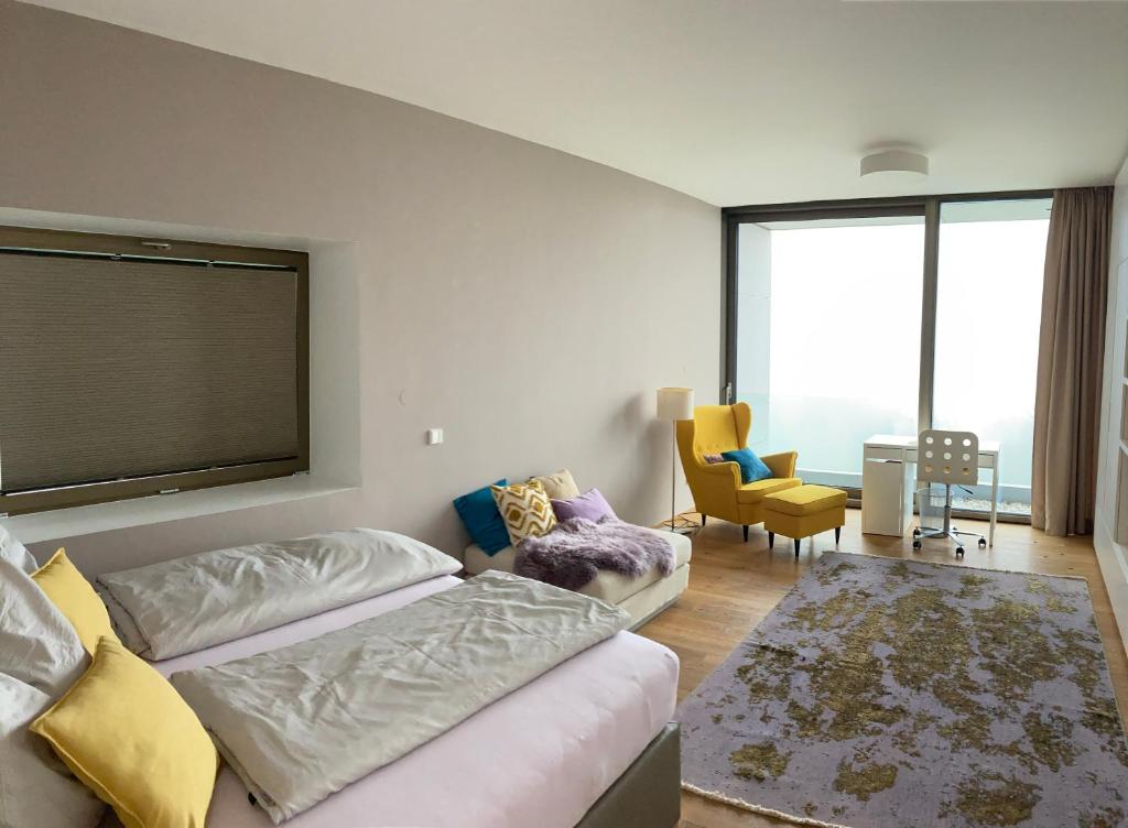 uma sala de estar com uma cama e um sofá em Attersee Luxury Design Villa with dream views, large Pool and Sauna em Nussdorf am Attersee