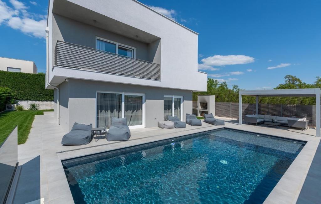 una casa con piscina delante de una casa en Villa Athos, en Karigador